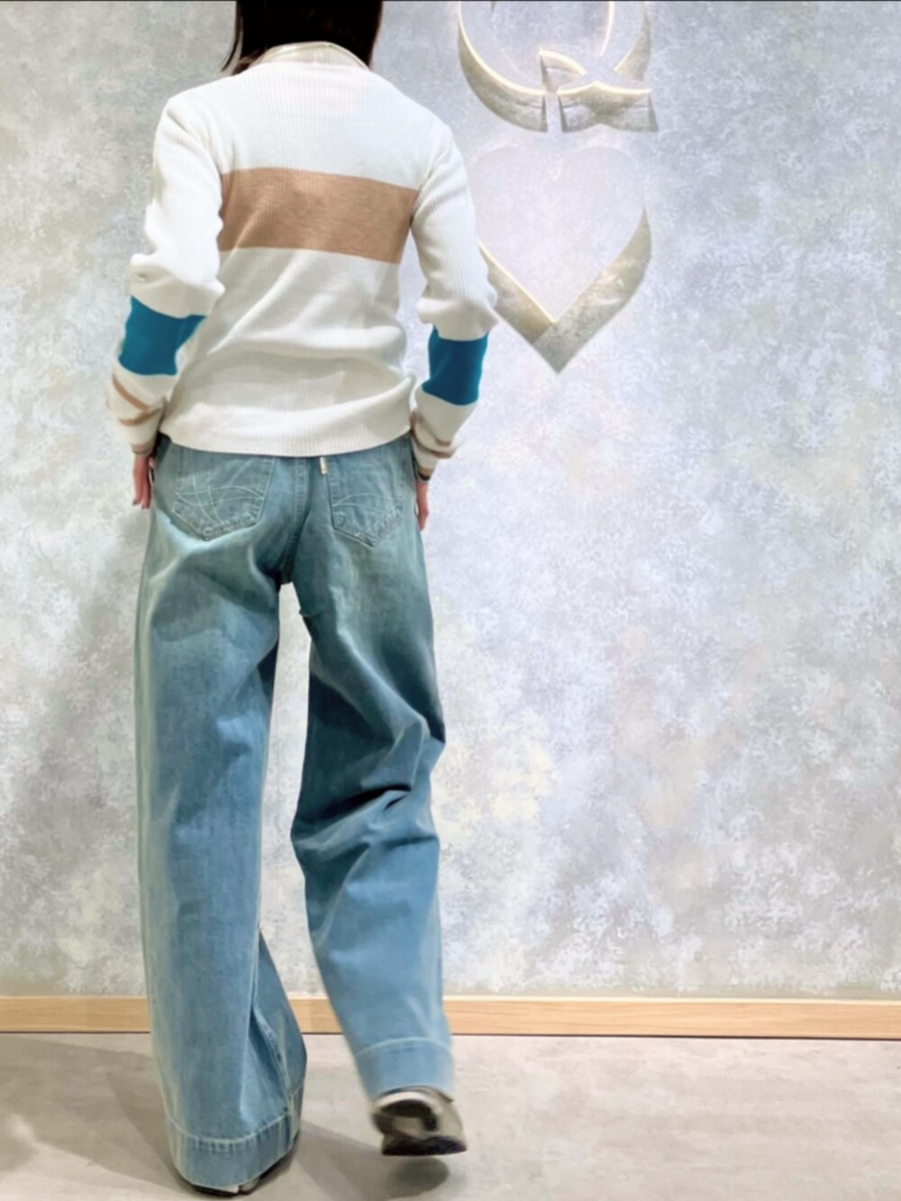 ブルー系のデニムパンツ、ホワイト系のニット/セーターを着用したレディースの冬コーディネートの4枚目の写真