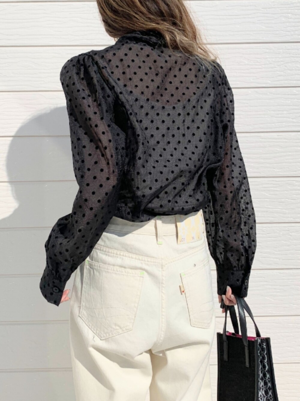 ブラック系のショルダーバッグ、ホワイト系のデニムパンツ、ブラック系のシャツ/ブラウスを着用したレディースの春コーディネートの5枚目の写真