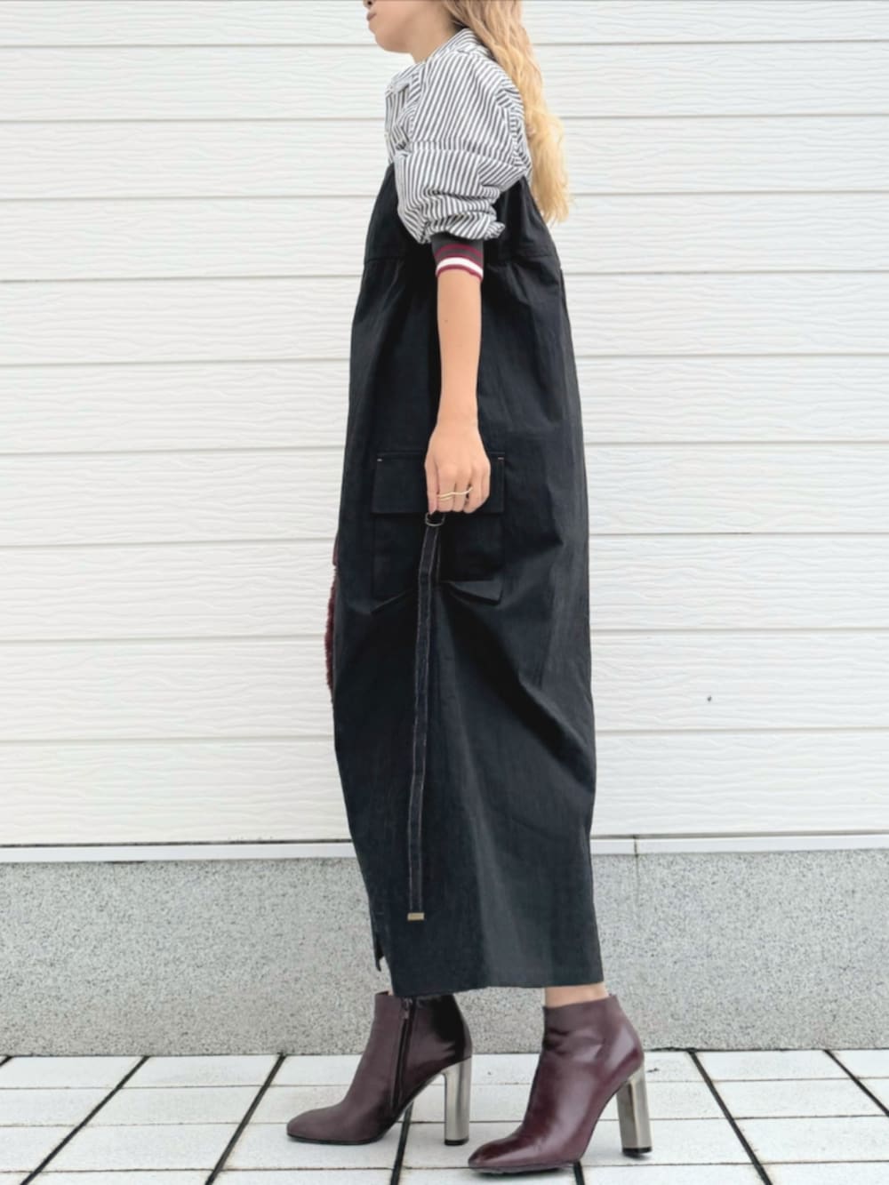 ブラウン系のブーツ、ブラック系のジャンパースカート、ブラック系のシャツ/ブラウスを着用したレディースの秋コーディネートの3枚目の写真