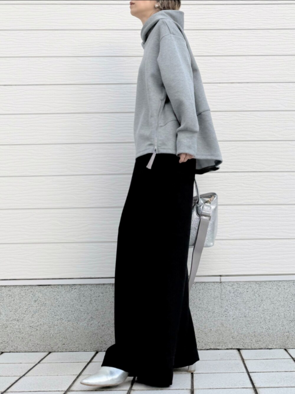 シルバー系のトートバッグ、ブラック系のその他パンツ、グレー系のパーカーを着用したレディースの冬コーディネートの2枚目の写真