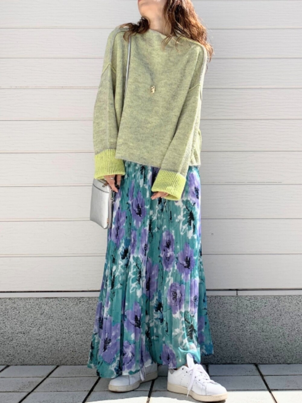 グリーン系のスカート、ホワイト系のスニーカー、シルバー系のショルダーバッグを着用したレディースの秋コーディネートの2枚目の写真