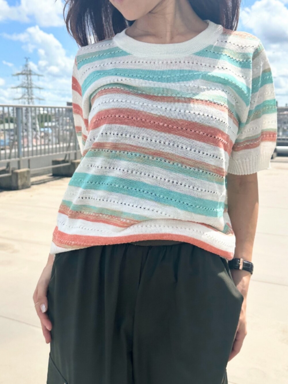 グリーン系のカーゴパンツ、その他のニット/セーターを着用したレディースの夏コーディネートの4枚目の写真