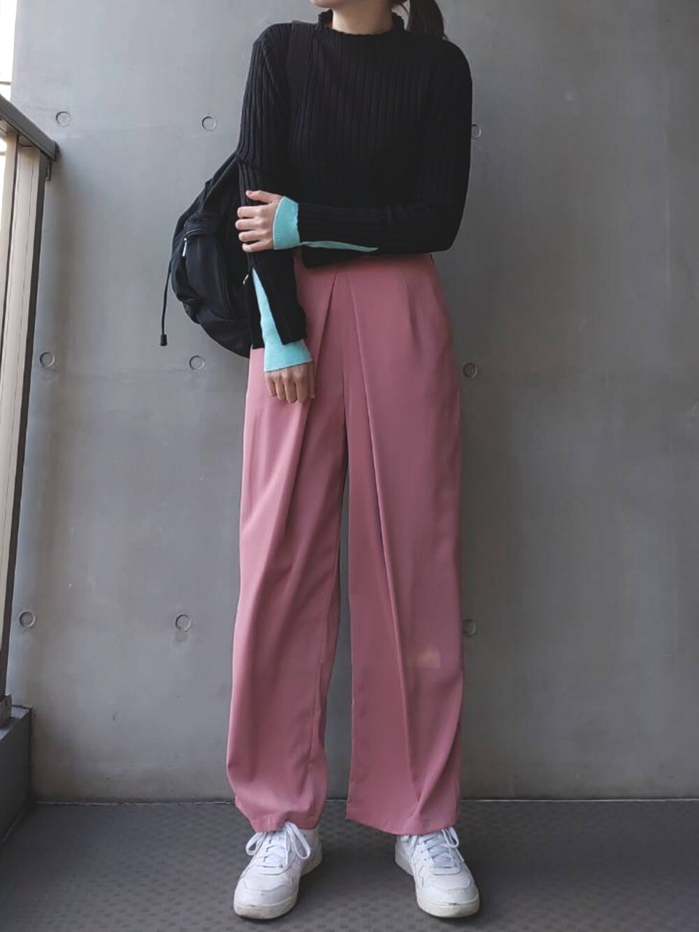 ブラック系のニット/セーター、ピンク系のその他パンツ、ホワイト系のスニーカーを着用したレディースの冬コーディネートの2枚目の写真
