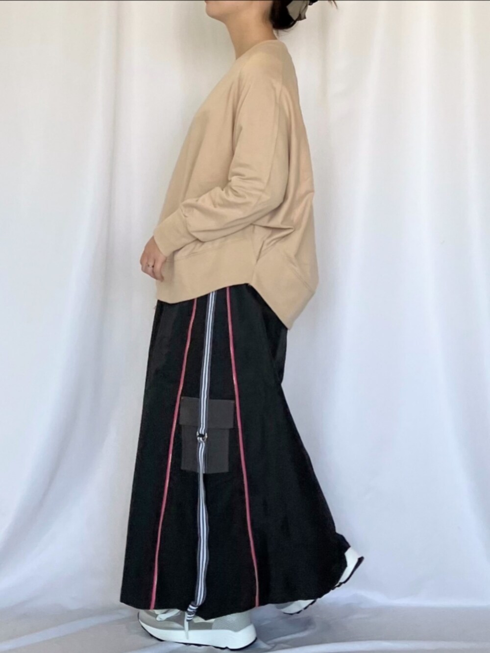 ベージュ系のスウェット、グレー系のスカート、シルバー系のスニーカーを着用したレディースの冬コーディネートの3枚目の写真