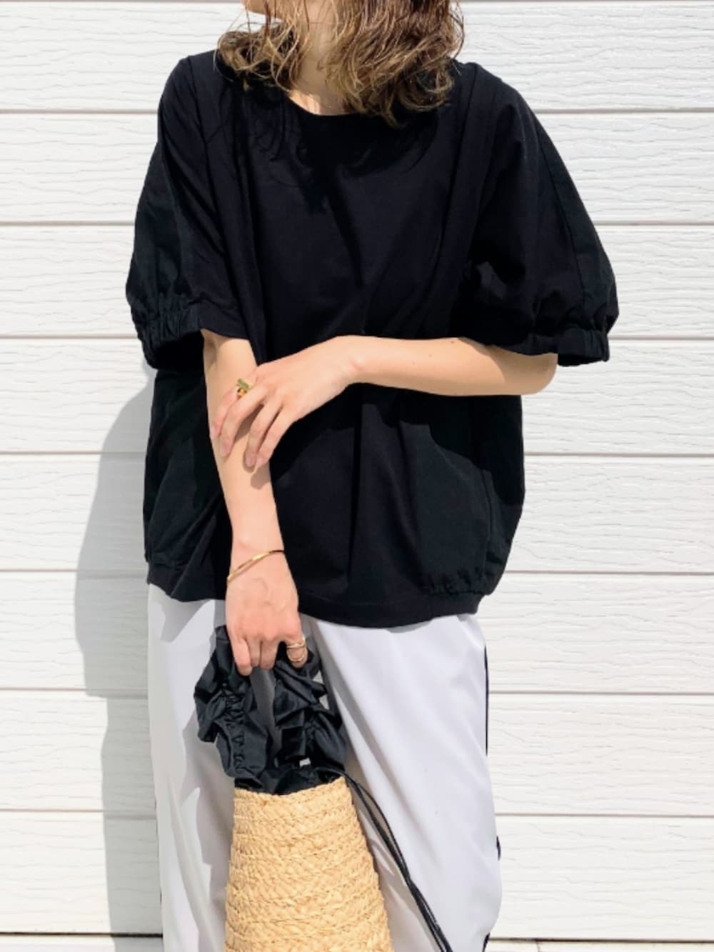 グレー系のその他パンツ、ブラック系のかごバッグ、ブラック系のTシャツ/カットソーを着用したレディースの春コーディネートの3枚目の写真