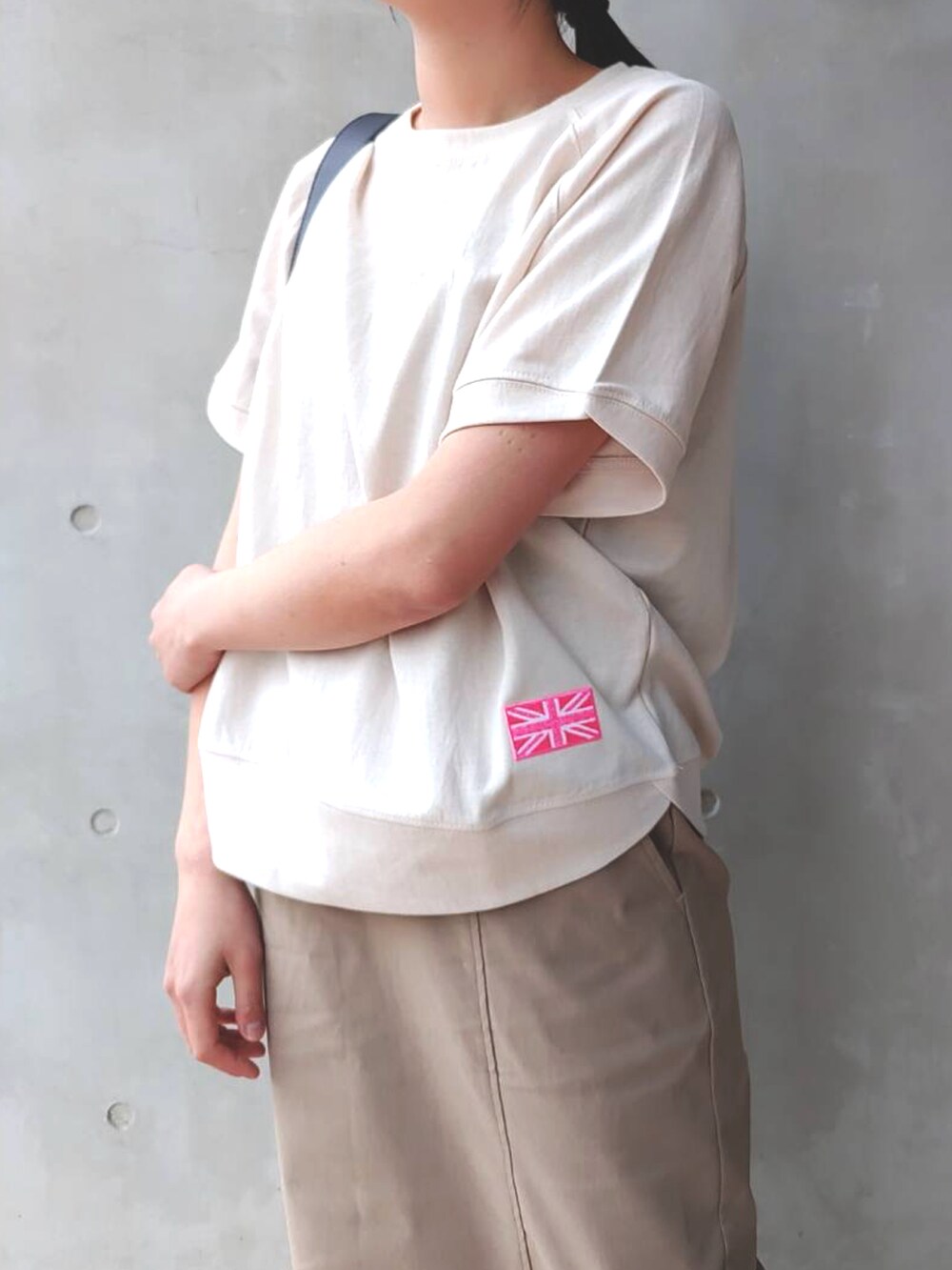 ベージュ系のスウェット、ホワイト系のスニーカー、ベージュ系のスカートを着用したレディースの春コーディネートの3枚目の写真