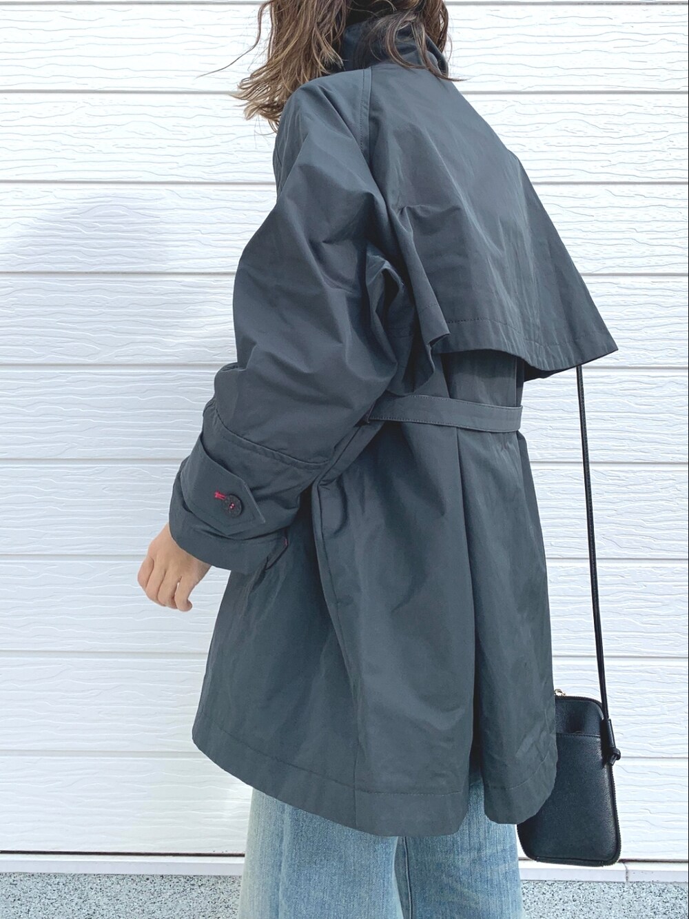 ブルー系のデニムパンツ、グレー系のその他アウター、ホワイト系のニット/セーターを着用したレディースの冬コーディネートの4枚目の写真