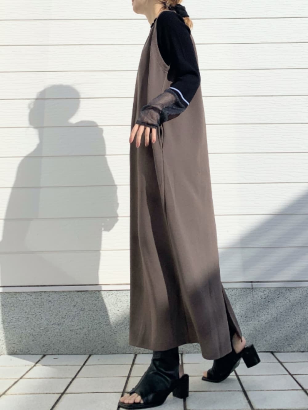 ブラック系のサンダル、ブラウン系のワンピース、ブラック系のニット/セーターを着用したレディースの冬コーディネートの2枚目の写真