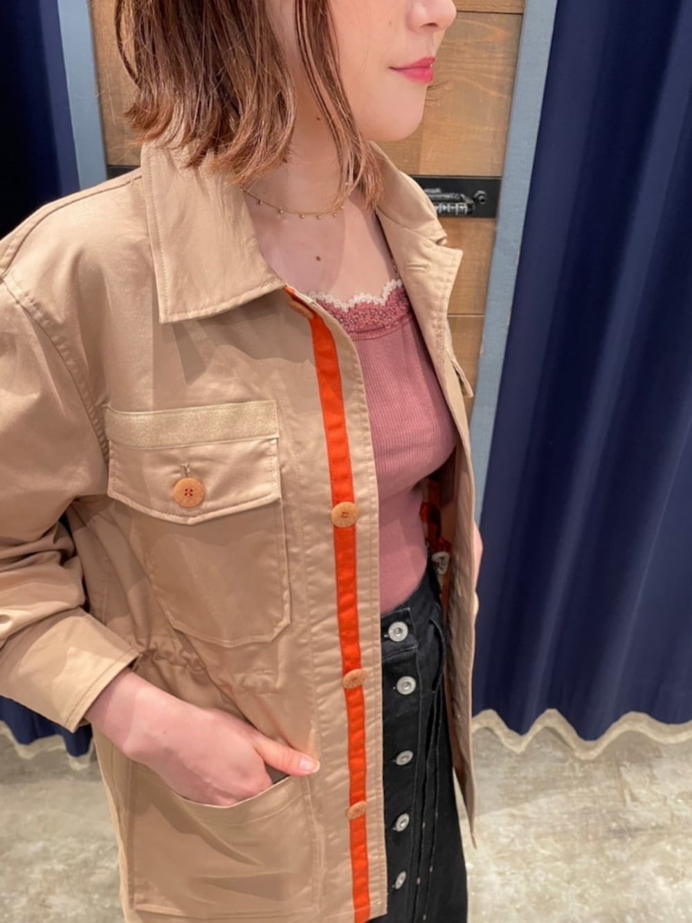 ブラック系のデニムスカート、シルバー系のサンダル、ベージュ系のミリタリージャケットを着用したレディースの秋コーディネートの2枚目の写真