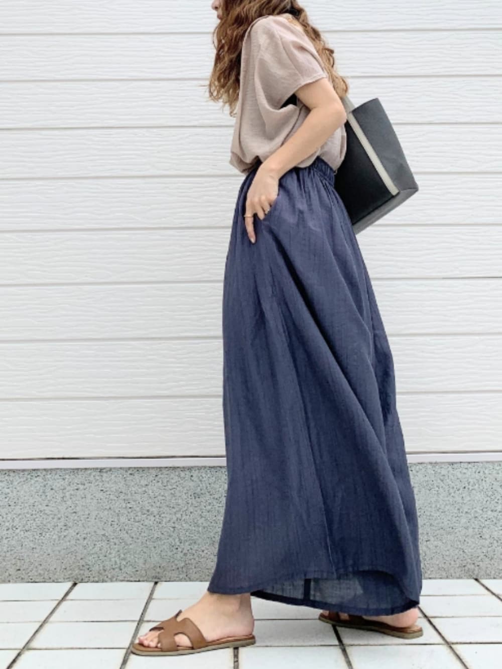 イエロー系のサンダル、グレー系のトートバッグ、ベージュ系のシャツ/ブラウスを着用したレディースの夏コーディネートの2枚目の写真