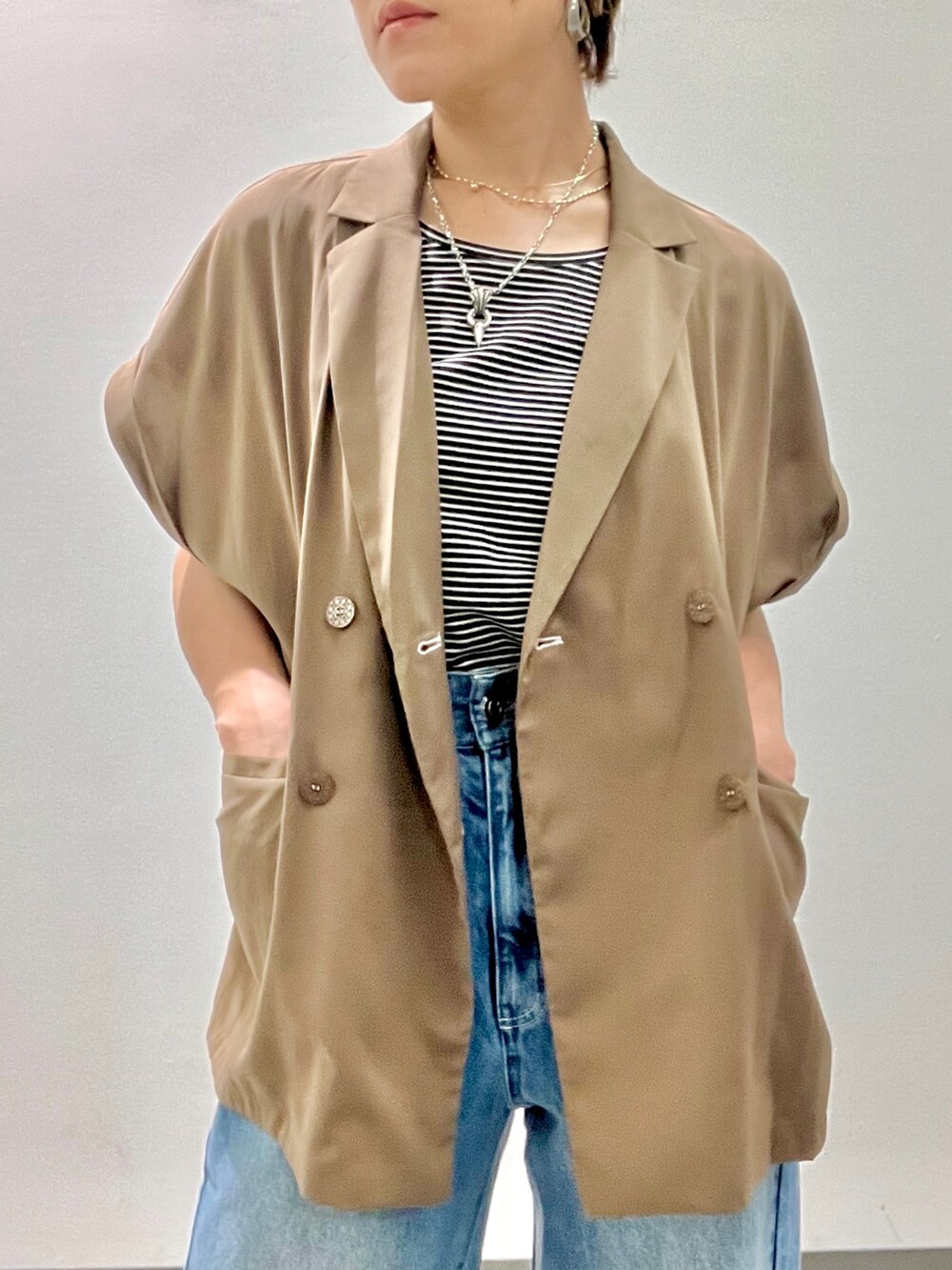 ブラック系のTシャツ/カットソー、グリーン系のテーラードジャケット、ブルー系のデニムパンツを着用したレディースの夏コーディネートの3枚目の写真