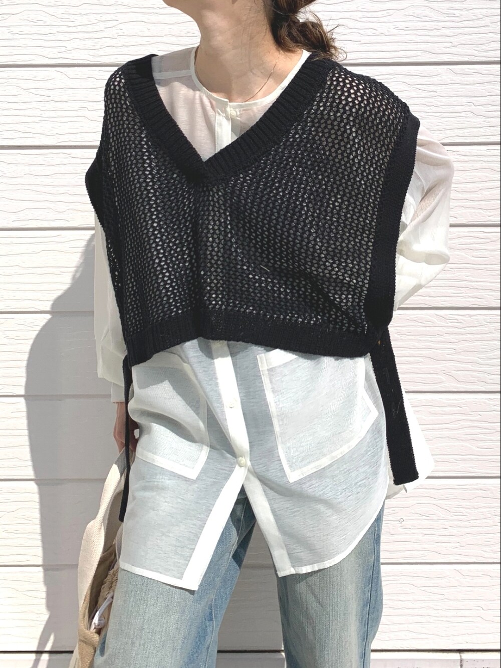 ブルー系のデニムパンツ、ブラック系のサンダル、ホワイト系のシャツ/ブラウスを着用したレディースの春コーディネートの4枚目の写真