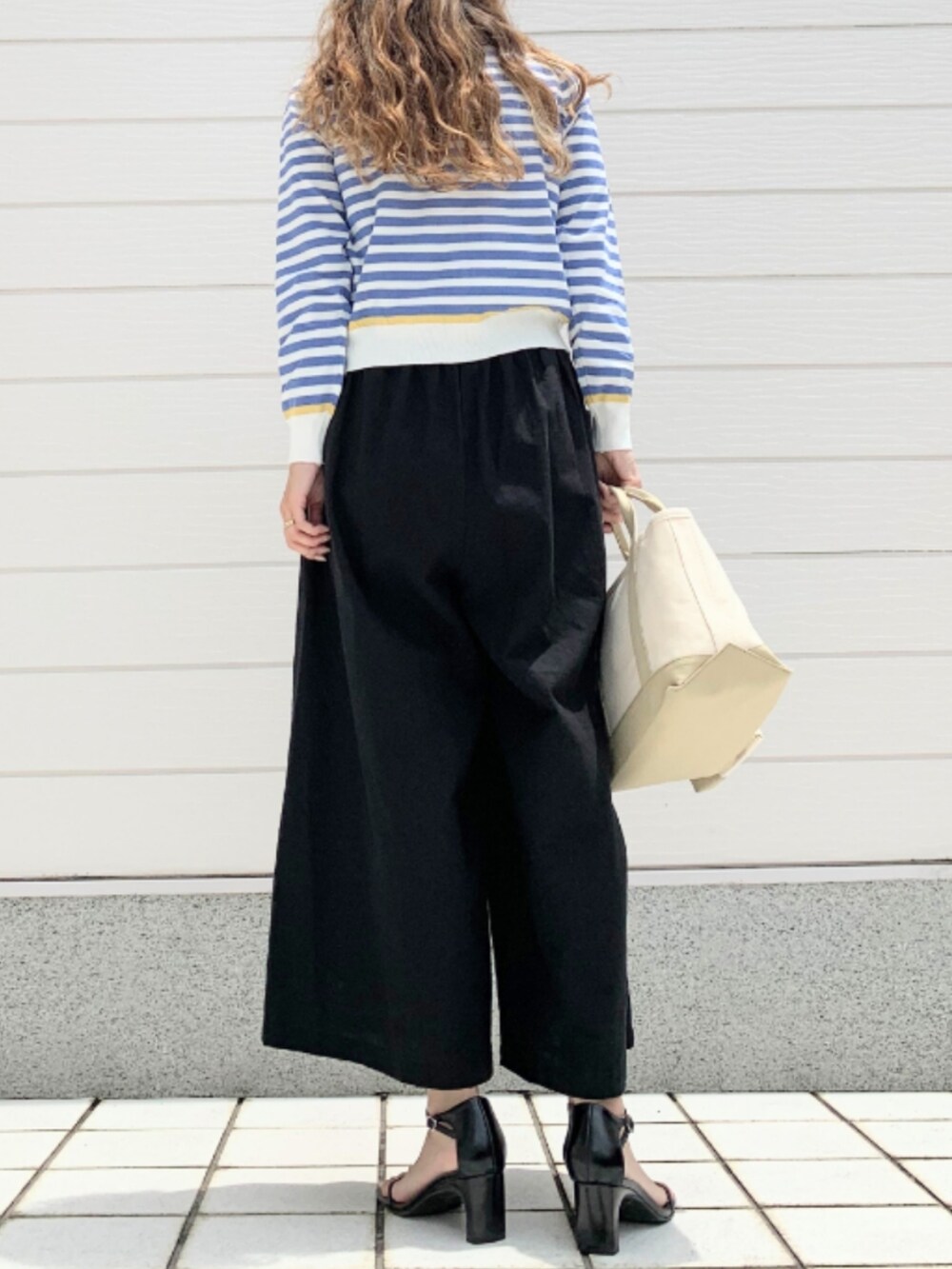 ベージュ系のトートバッグ、ブラック系のその他パンツ、ブルー系のカーディガン/ボレロを着用したレディースの夏コーディネートの3枚目の写真