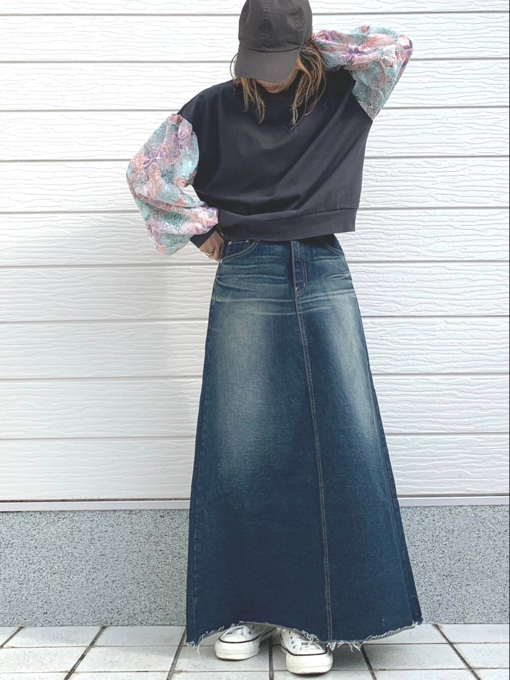 ブルー系のデニムスカート、グレー系のTシャツ/カットソー、ホワイト系のスニーカーを着用したレディースの冬コーディネートの2枚目の写真