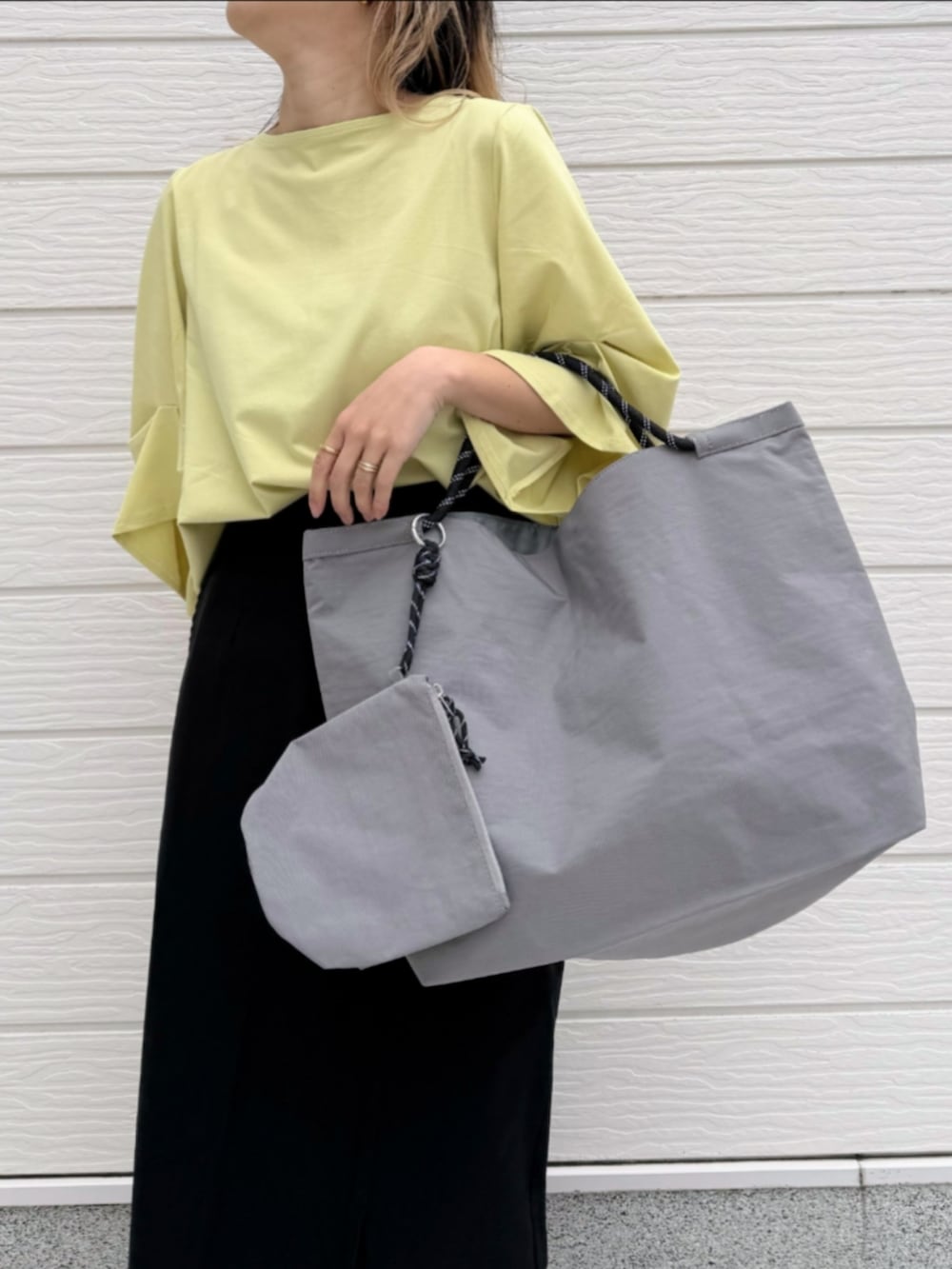 ブラック系のサンダル、ブラック系のスカート、イエロー系のTシャツ/カットソーを着用したレディースの春コーディネートの5枚目の写真