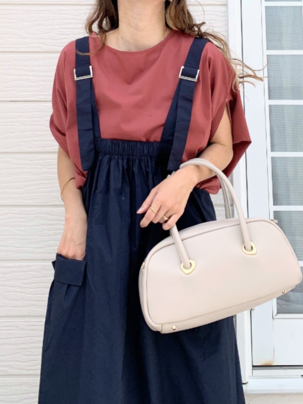 レッド系のTシャツ/カットソー、ブルー系のジャンパースカート、ホワイト系のボストンバッグを着用したレディースの夏コーディネートの4枚目の写真