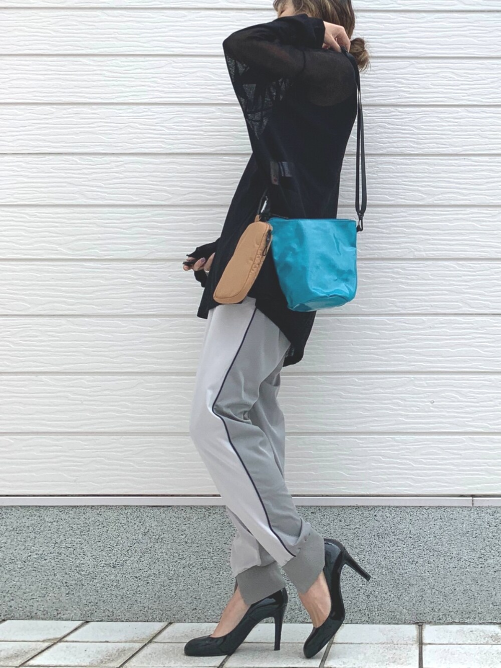 ブラック系のニット/セーター、グリーン系のショルダーバッグ、グレー系のその他パンツを着用したレディースの春コーディネートの2枚目の写真