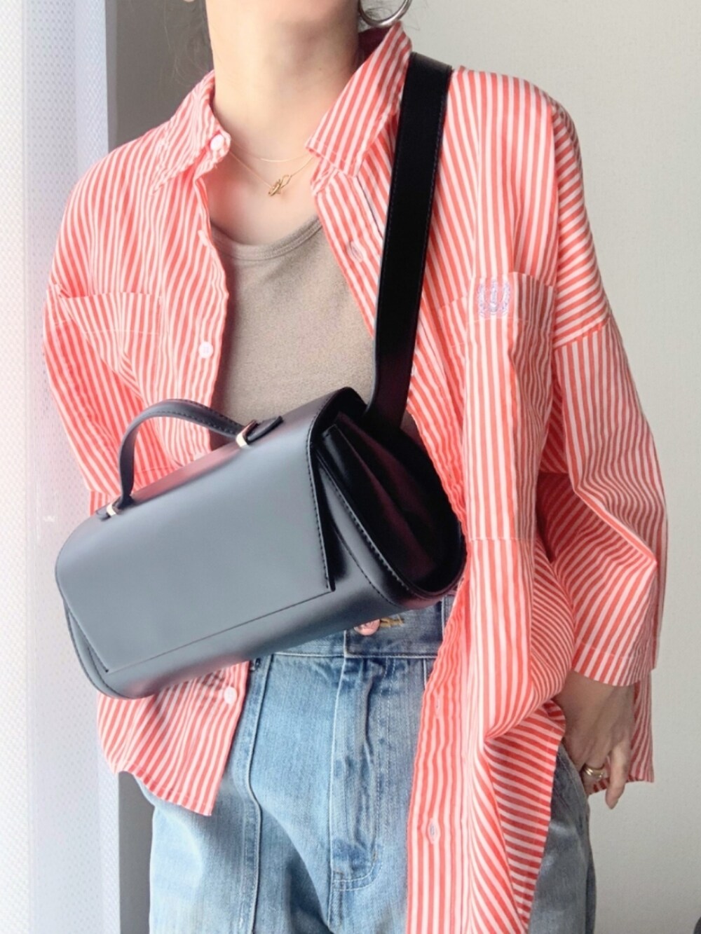 ブルー系のデニムパンツ、ベージュ系のタンクトップ、オレンジ系のシャツ/ブラウスを着用したレディースの夏コーディネートの5枚目の写真