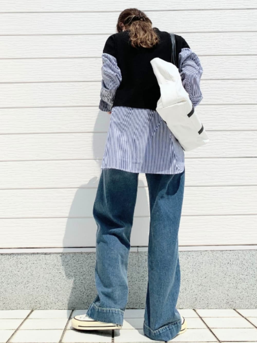 ホワイト系のトートバッグ、ブルー系のデニムパンツ、ホワイト系のスニーカーを着用したレディースの夏コーディネートの3枚目の写真