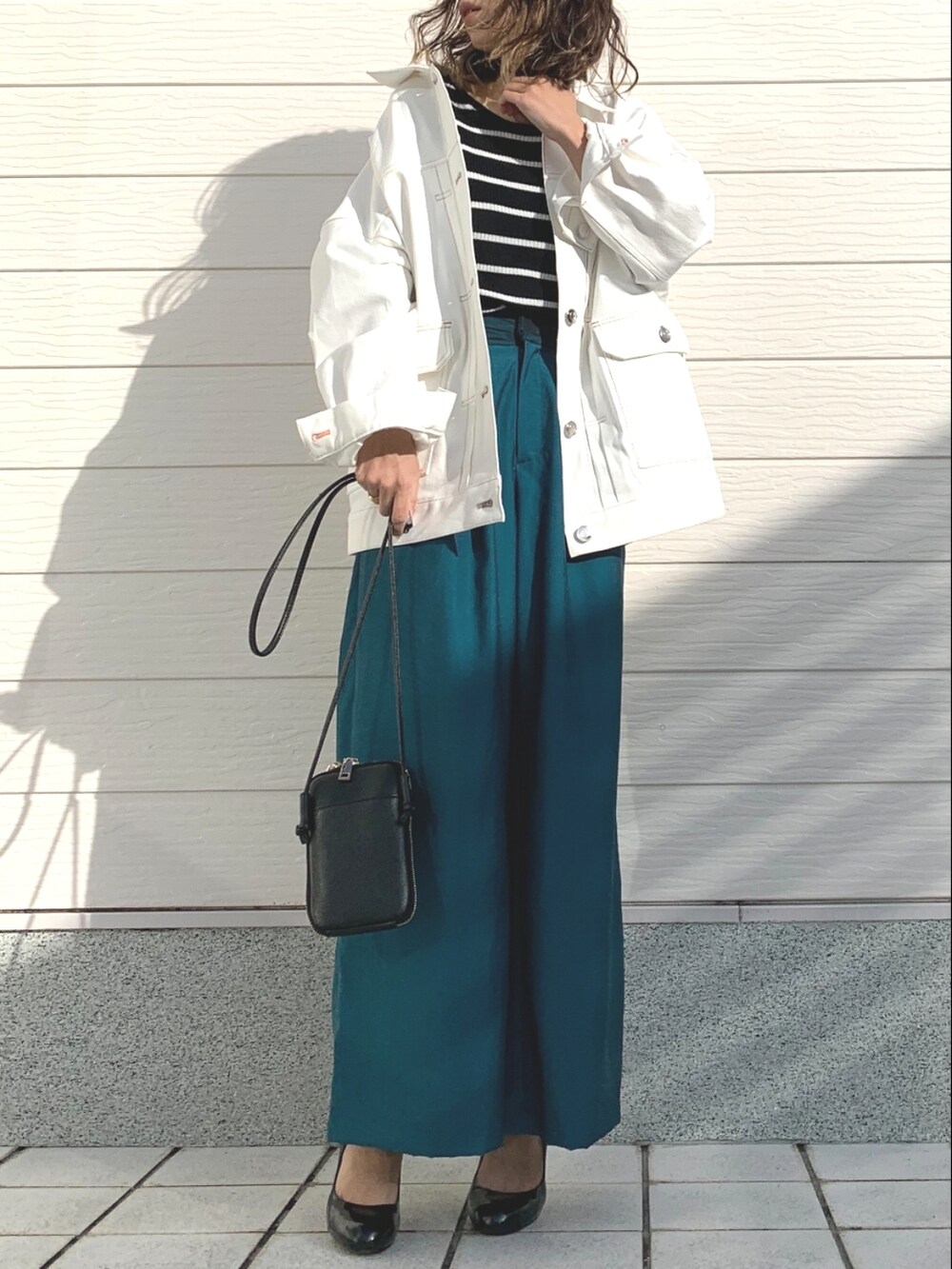 ブラック系のニット/セーター、ブルー系のその他パンツ、ブラック系のショルダーバッグを着用したレディースの冬コーディネートの2枚目の写真