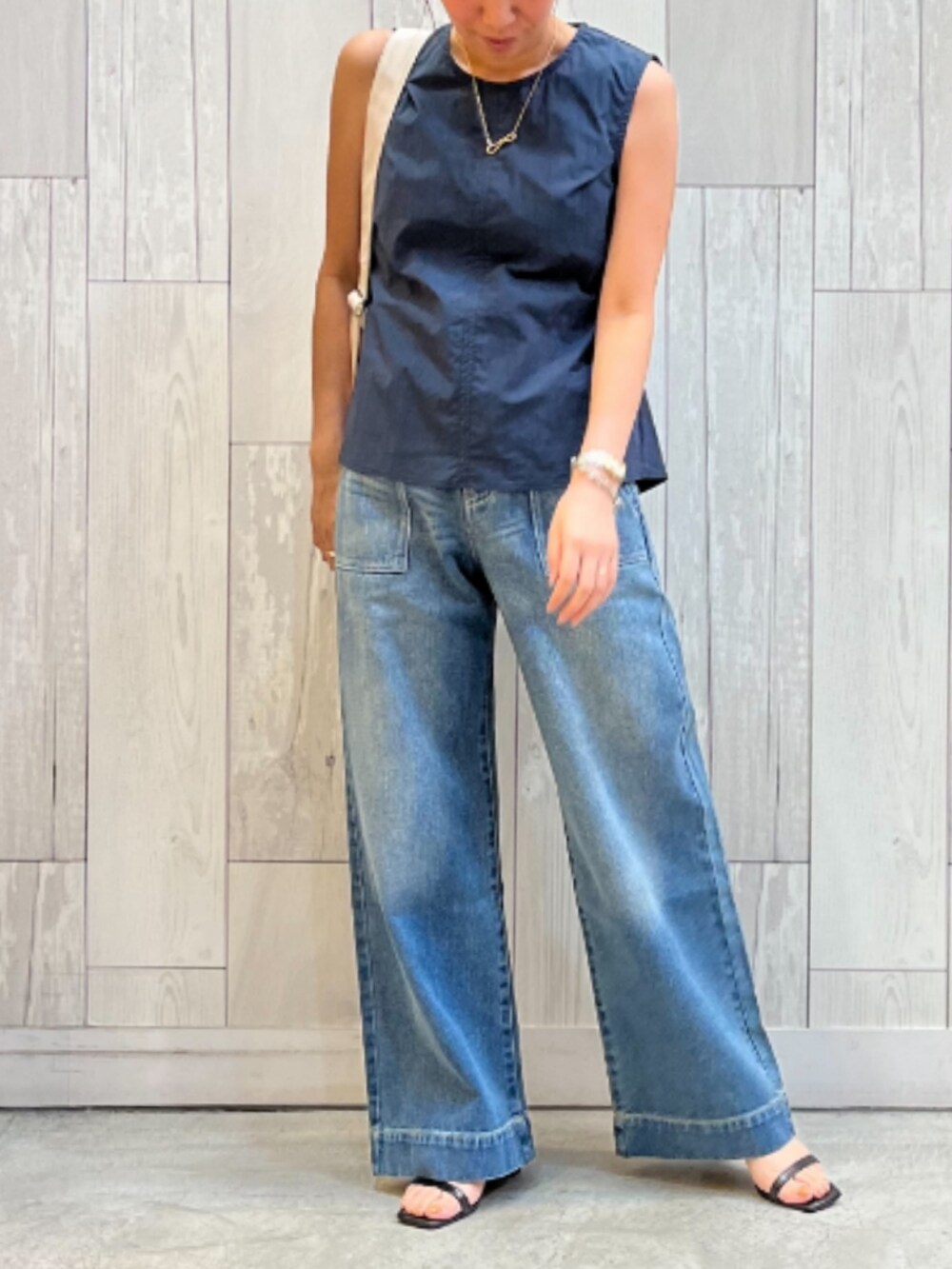 ブルー系のデニムパンツ、ブルー系のシャツ/ブラウス、ホワイト系のバックパック/リュックを着用したレディースの夏コーディネートの2枚目の写真