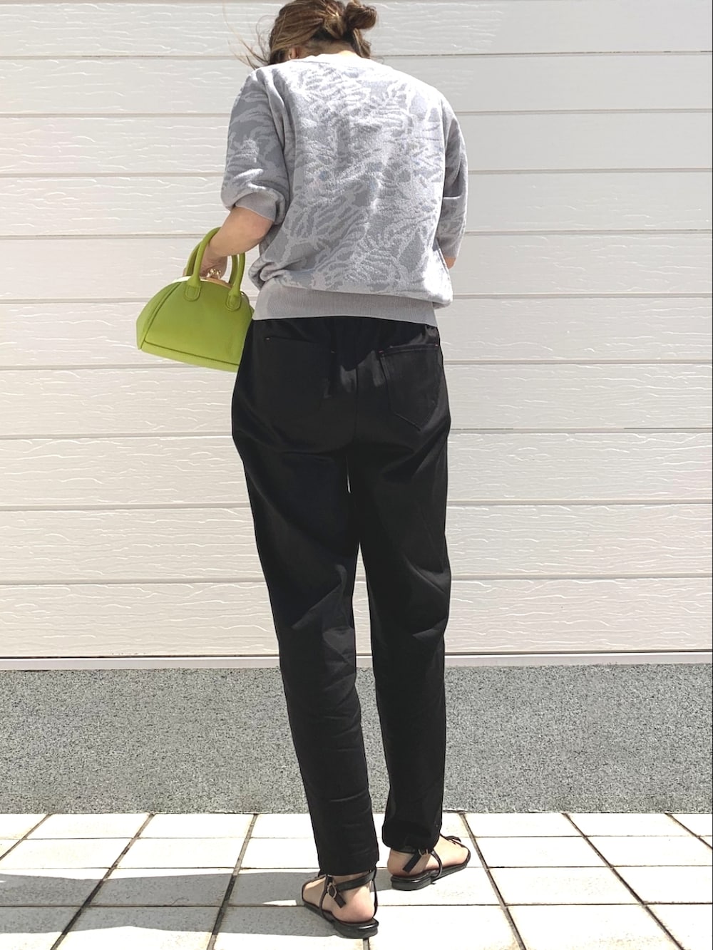 ブラック系のその他パンツ、グリーン系のショルダーバッグ、グレー系のニット/セーターを着用したレディースの春コーディネートの3枚目の写真