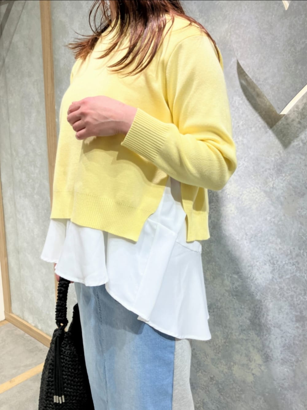 ブルー系のスカート、ブラック系のトートバッグ、イエロー系のニット/セーターを着用したレディースの冬コーディネートの4枚目の写真