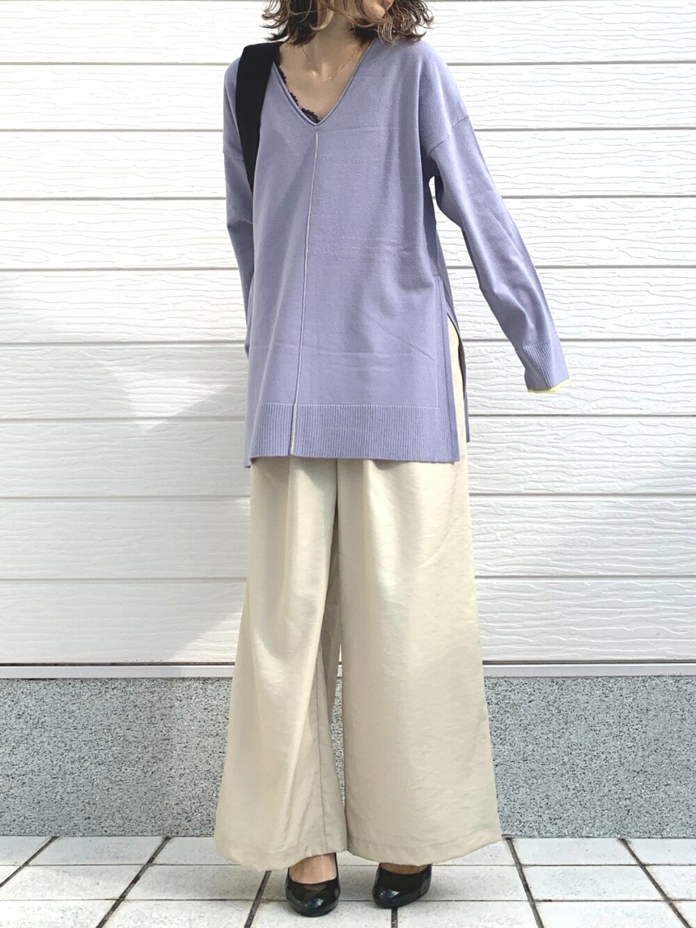 ベージュ系のその他パンツ、パープル系のニット/セーター、ブラック系のショルダーバッグを着用したレディースの冬コーディネートの2枚目の写真