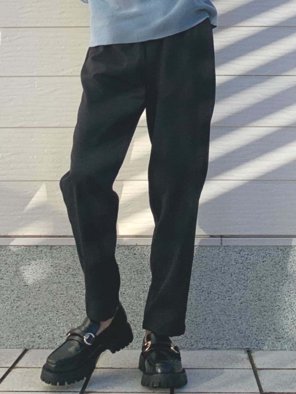 ブラック系のその他パンツ、ブラック系のローファー、ブルー系のニット/セーターを着用したレディースの冬コーディネートの3枚目の写真