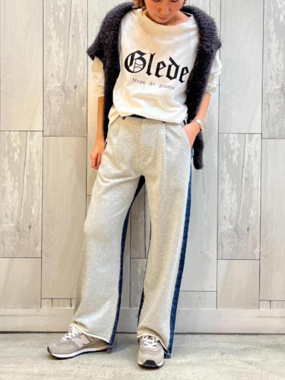 グレー系のデニムパンツ、ホワイト系のTシャツ/カットソー、グレー系のニット/セーターを着用したレディースの冬コーディネートの2枚目の写真