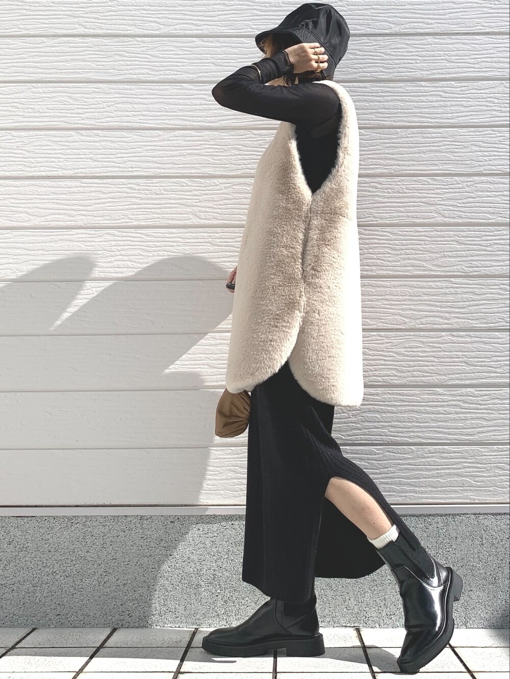 ブラウン系のバッグ、ブラック系のTシャツ/カットソー、ブラック系のスカートを着用したレディースの秋コーディネートの2枚目の写真