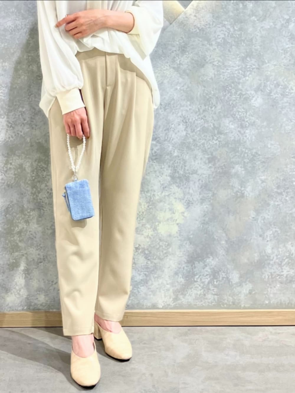 ベージュ系のその他パンツ、ホワイト系のシャツ/ブラウス、ブルー系のその他小物を着用したレディースの春コーディネートの5枚目の写真