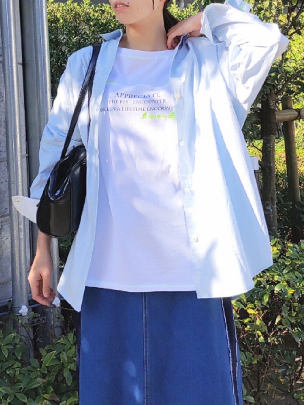 ブルー系のデニムスカート、ホワイト系のスニーカー、ホワイト系のTシャツ/カットソーを着用したレディースの冬コーディネートの3枚目の写真