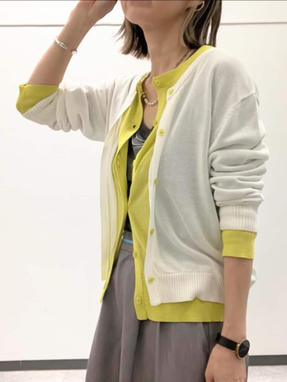 グレー系のスラックス、ホワイト系のTシャツ/カットソー、ホワイト系のカーディガン/ボレロを着用したレディースの春コーディネートの5枚目の写真