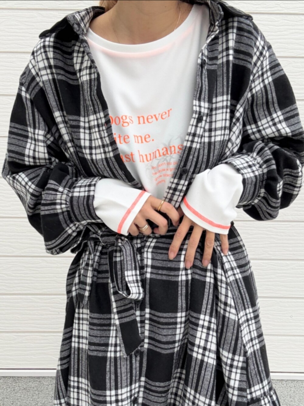 ブラック系のブーツ、ブラック系のシャツワンピース、ホワイト系のTシャツ/カットソーを着用したレディースの秋コーディネートの5枚目の写真