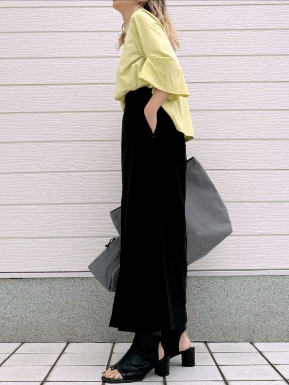 ブラック系のサンダル、ブラック系のスカート、イエロー系のTシャツ/カットソーを着用したレディースの春コーディネートの2枚目の写真