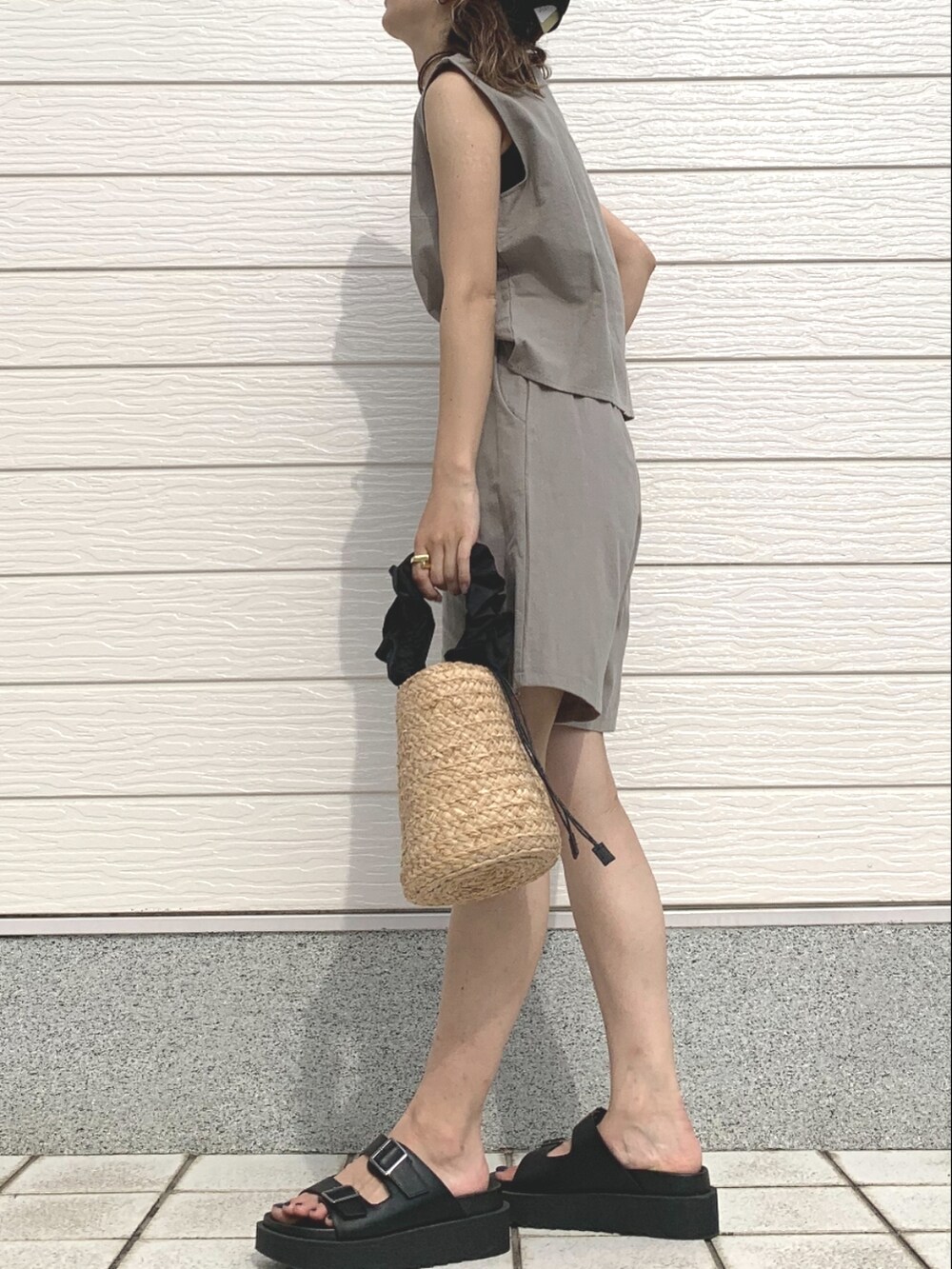 ブラック系のかごバッグ、ブラック系のサンダル、グリーン系のセットアップを着用したレディースの春コーディネートの2枚目の写真