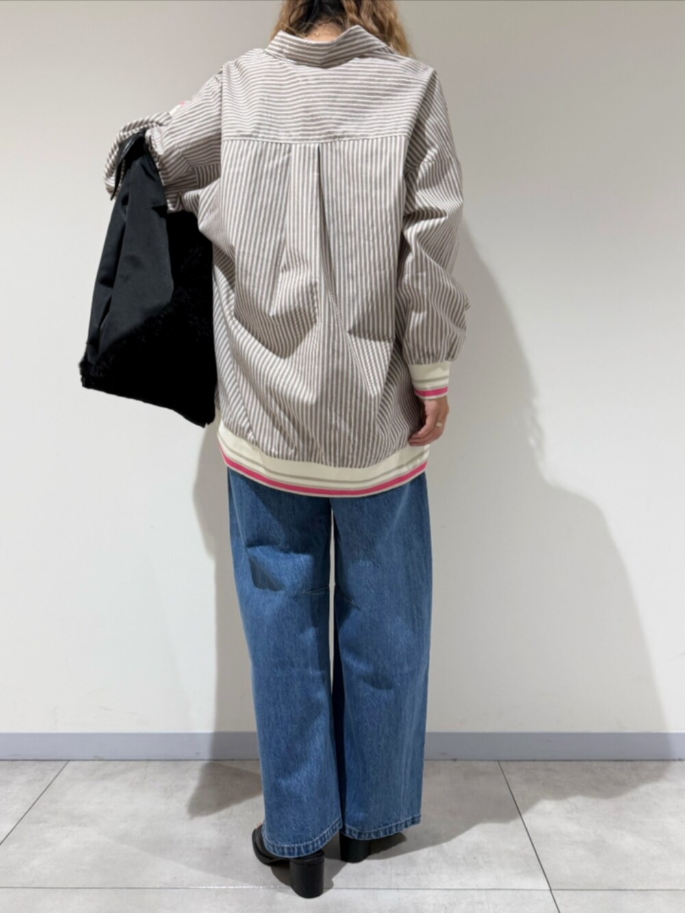 ブラック系のサンダル、ブルー系のデニムパンツ、ベージュ系のシャツ/ブラウスを着用したレディースの秋コーディネートの3枚目の写真