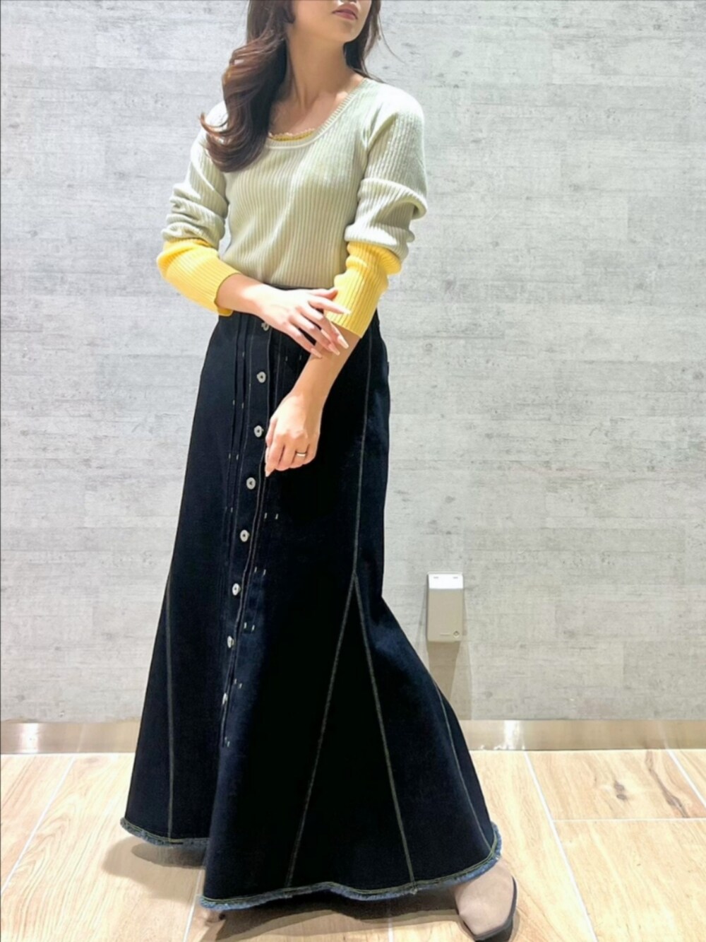 ブルー系のデニムスカート、グレー系のニット/セーターを着用したレディースの冬コーディネートの2枚目の写真