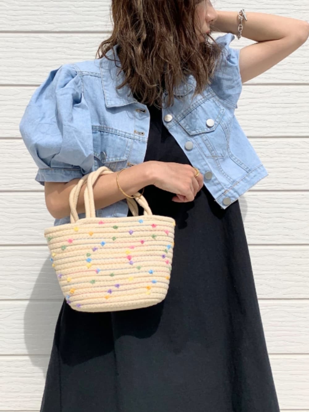 ブラック系のサンダル、ホワイト系のかごバッグ、ブルー系のデニムジャケットを着用したレディースの夏コーディネートの3枚目の写真