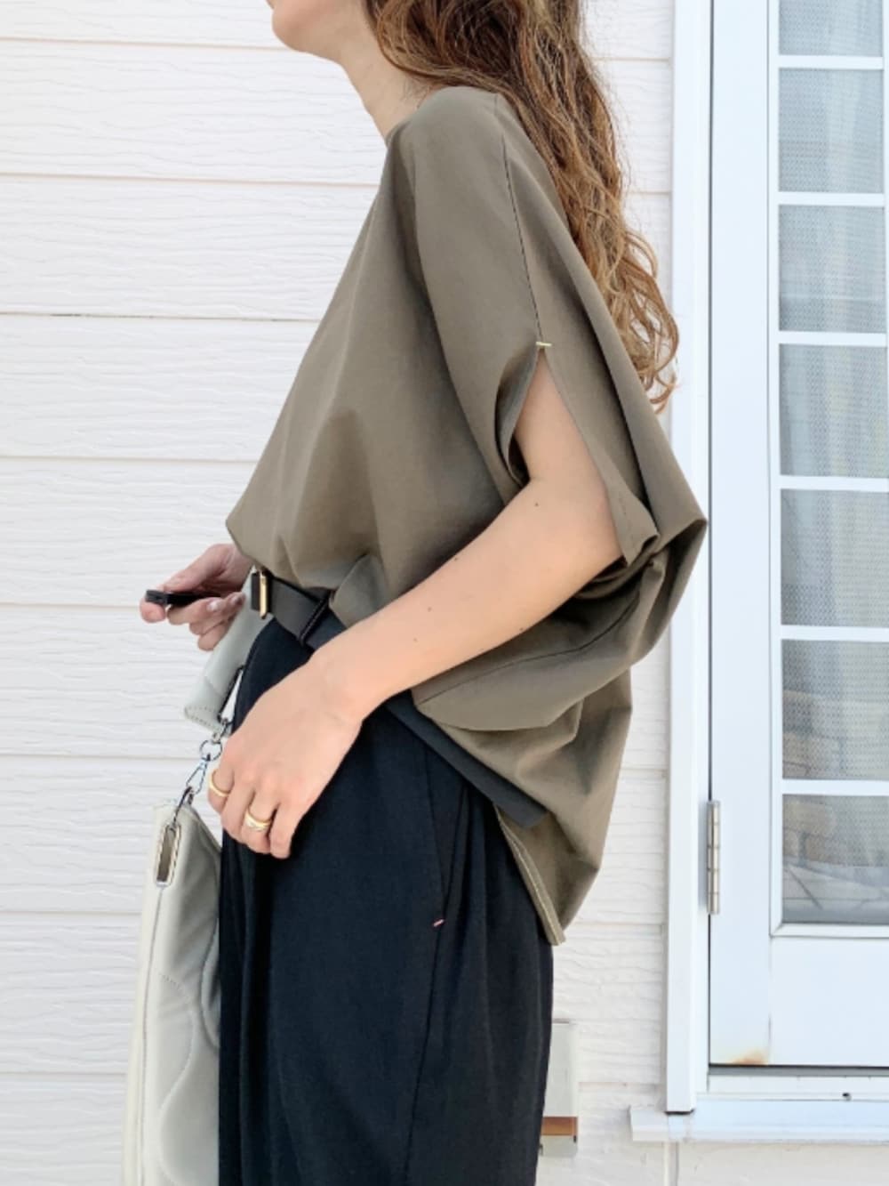 ブラック系のその他パンツ、ホワイト系のスニーカー、グリーン系のTシャツ/カットソーを着用したレディースの夏コーディネートの4枚目の写真