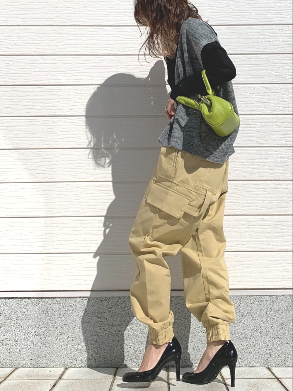 ベージュ系のその他パンツ、グリーン系のショルダーバッグ、ブラック系のTシャツ/カットソーを着用したレディースの春コーディネートの3枚目の写真