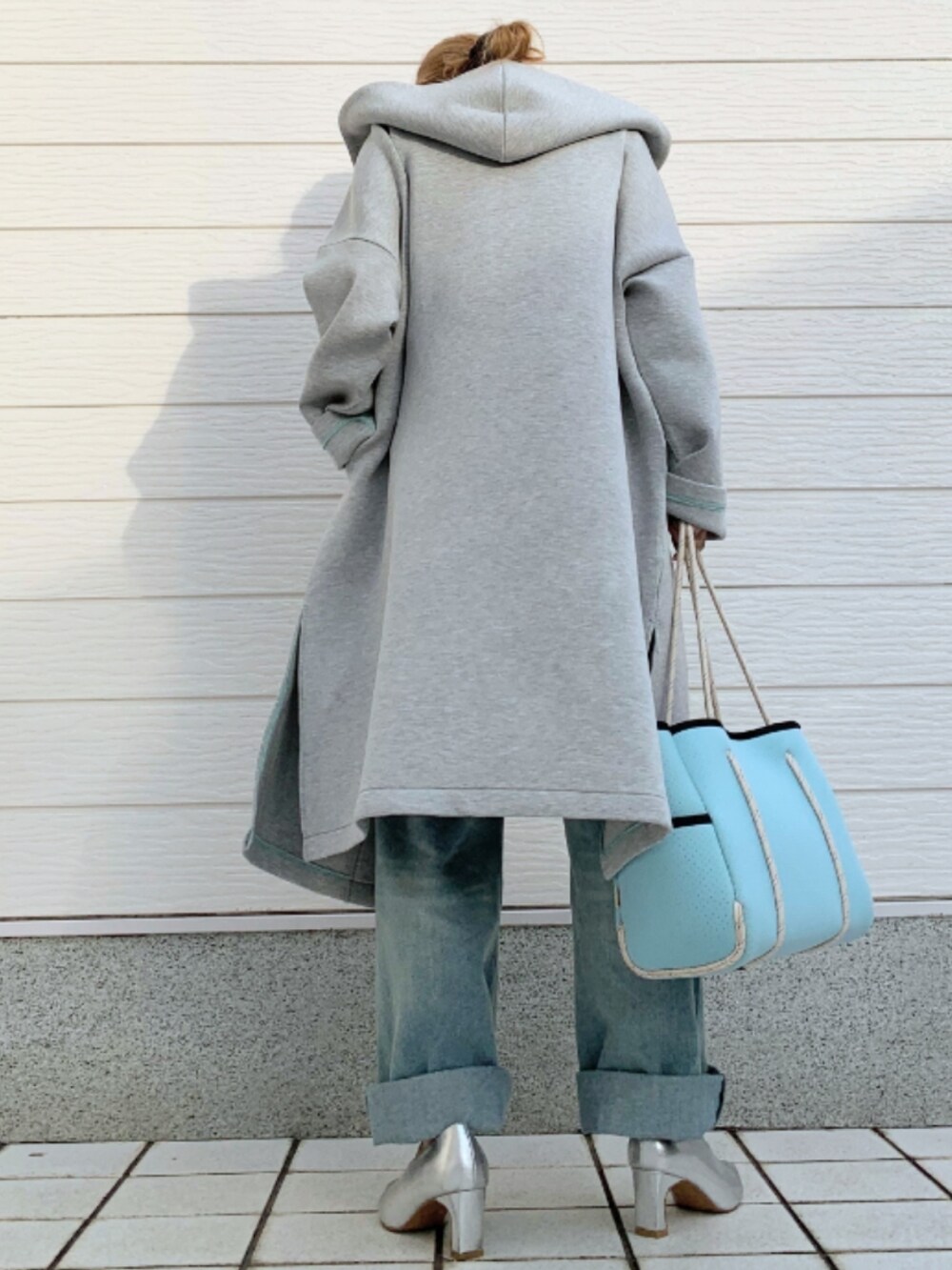 ブルー系のトートバッグ、ホワイト系のTシャツ/カットソー、グレー系のその他アウターを着用したレディースの冬コーディネートの3枚目の写真