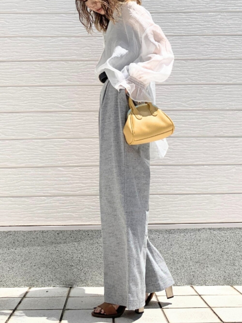 ブラウン系のサンダル、グレー系のその他パンツ、イエロー系のショルダーバッグを着用したレディースの春コーディネートの2枚目の写真