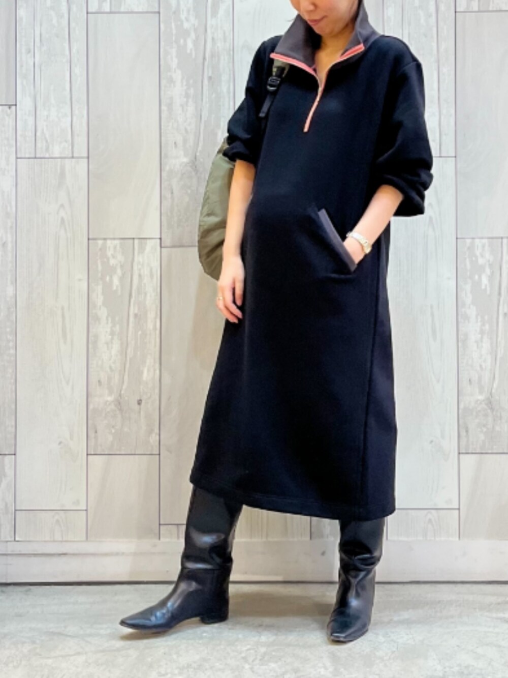 ブラック系のワンピース、グリーン系のボストンバッグを着用したレディースの秋コーディネートの2枚目の写真