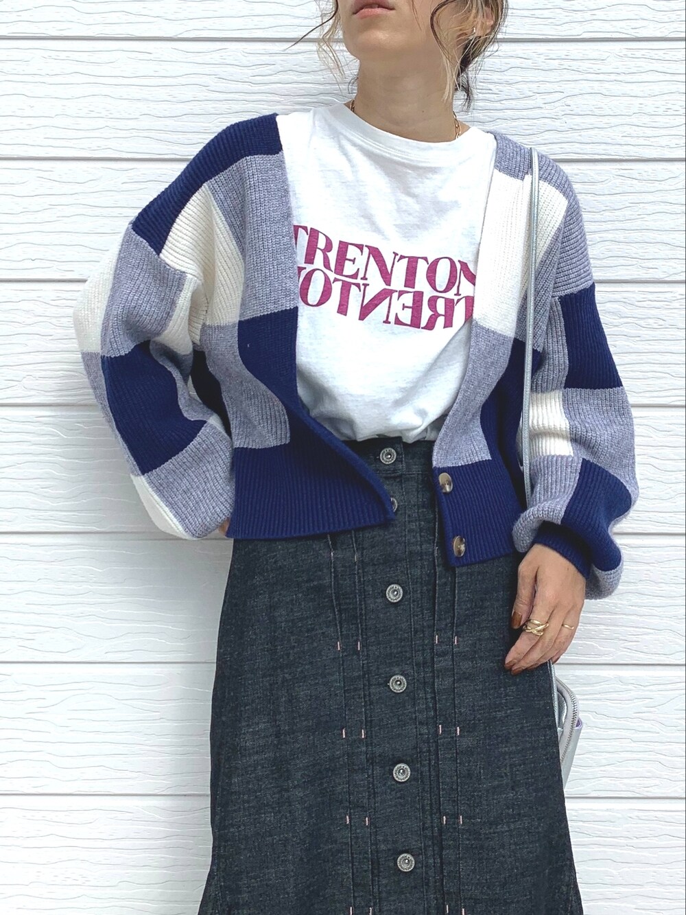 ホワイト系のTシャツ/カットソー、ブラック系のデニムスカート、ブラウン系のブーツを着用したレディースの秋コーディネートの3枚目の写真