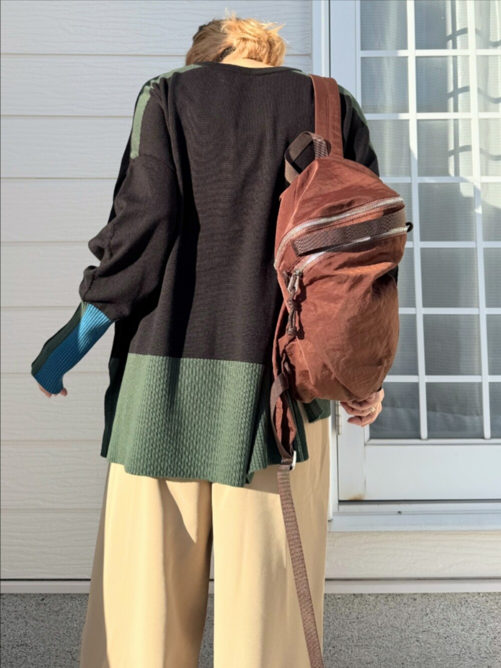 ベージュ系のその他パンツ、ブラック系のニット/セーター、ブラウン系のバックパック/リュックを着用したレディースの秋コーディネートの4枚目の写真