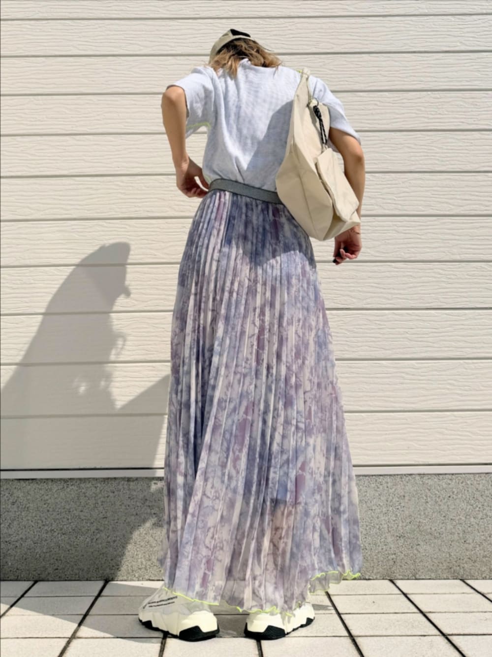 グレー系のTシャツ/カットソー、ホワイト系のトートバッグ、パープル系のスカートを着用したレディースの春コーディネートの3枚目の写真