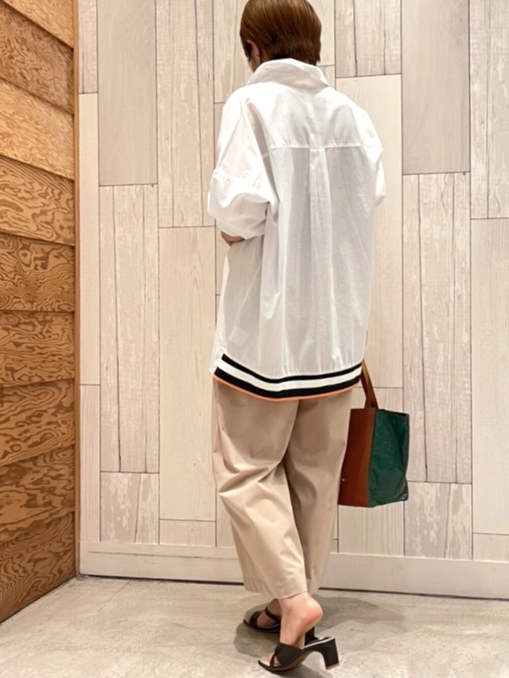 ブラック系のサンダル、ベージュ系のその他パンツ、グリーン系のトートバッグを着用したレディースの夏コーディネートの2枚目の写真