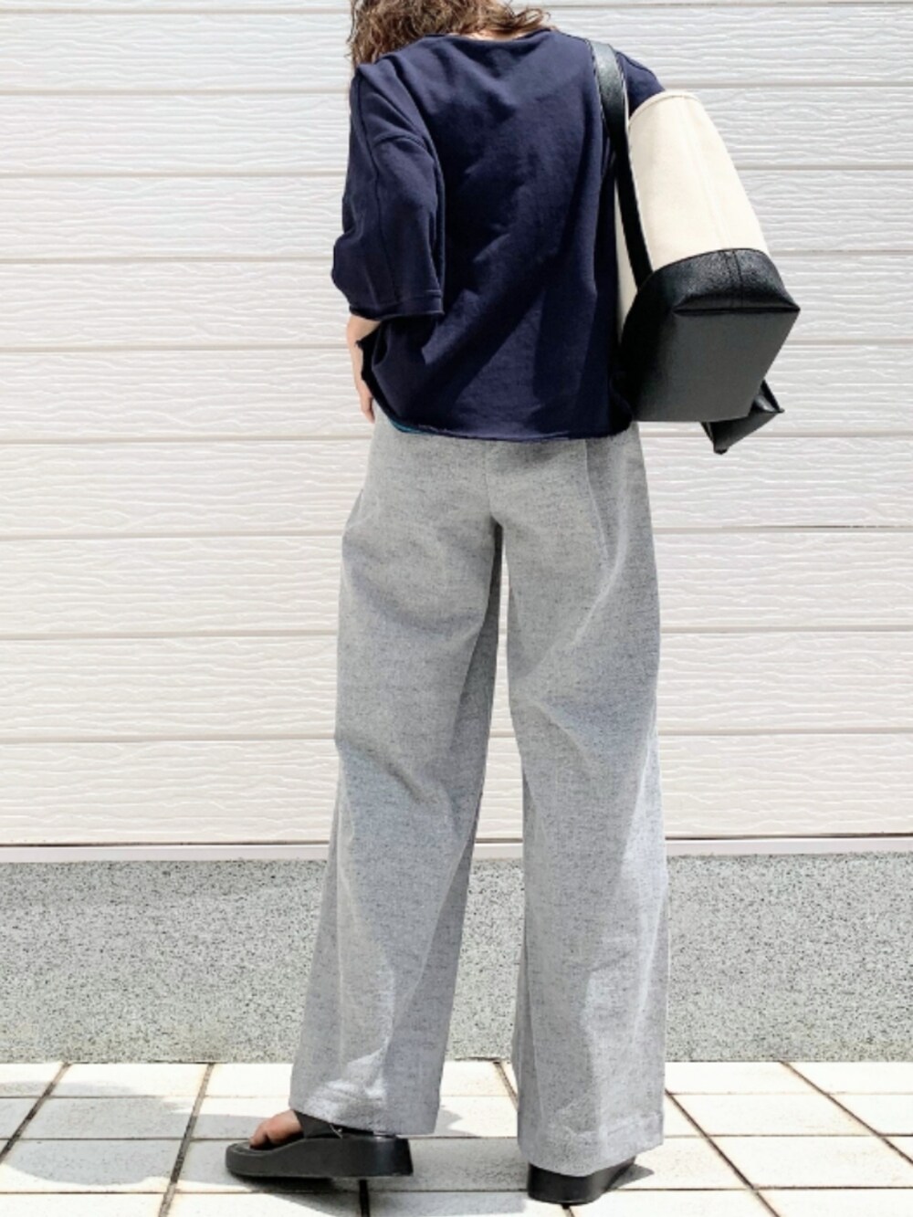 ブルー系のスウェット、グレー系のその他パンツ、ブラック系のハンドバッグを着用したレディースの春コーディネートの2枚目の写真
